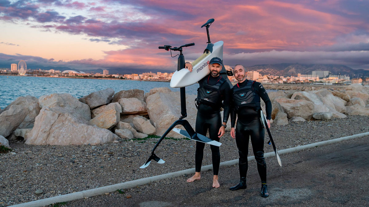 Portrait of two man standing on a dock carrying the Hydrofoiler SL3 water bike